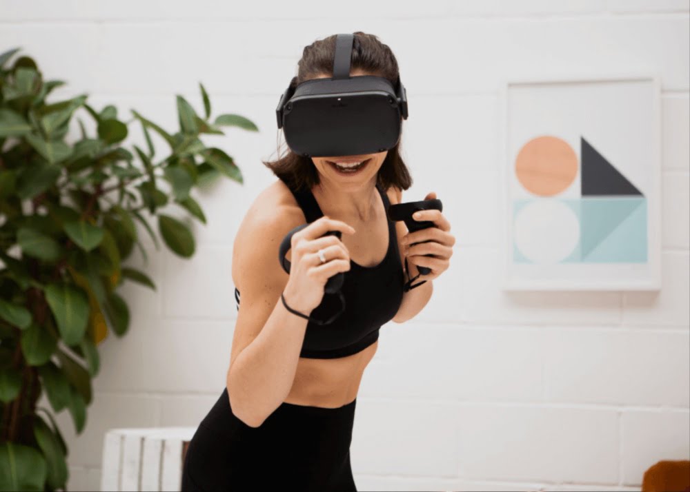A woman plays a fitness VR game on the Oculus Quest VR goggles.
