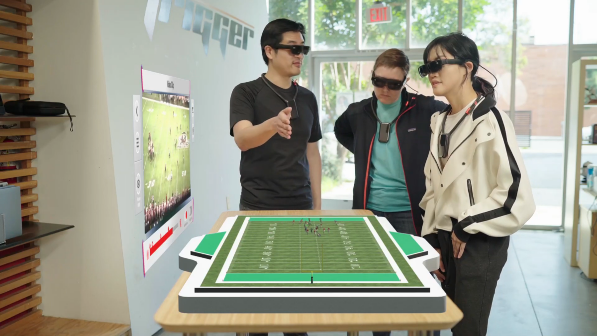 Three users wearing AR glasses and 5G collars analyze a virtual game recording on a table in front of them.