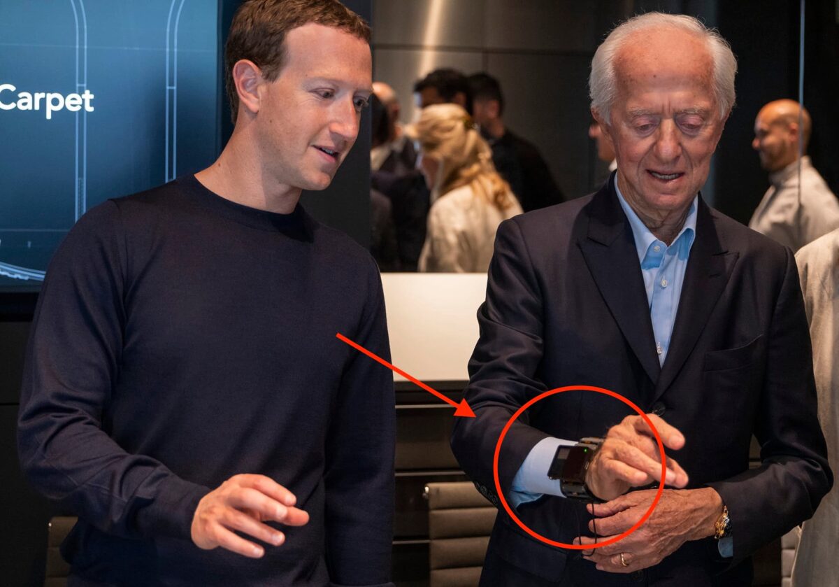 Luxottica founder Leonardo Del Vecchio stands next to Zuckerberg and tries out the EMG bracelet.