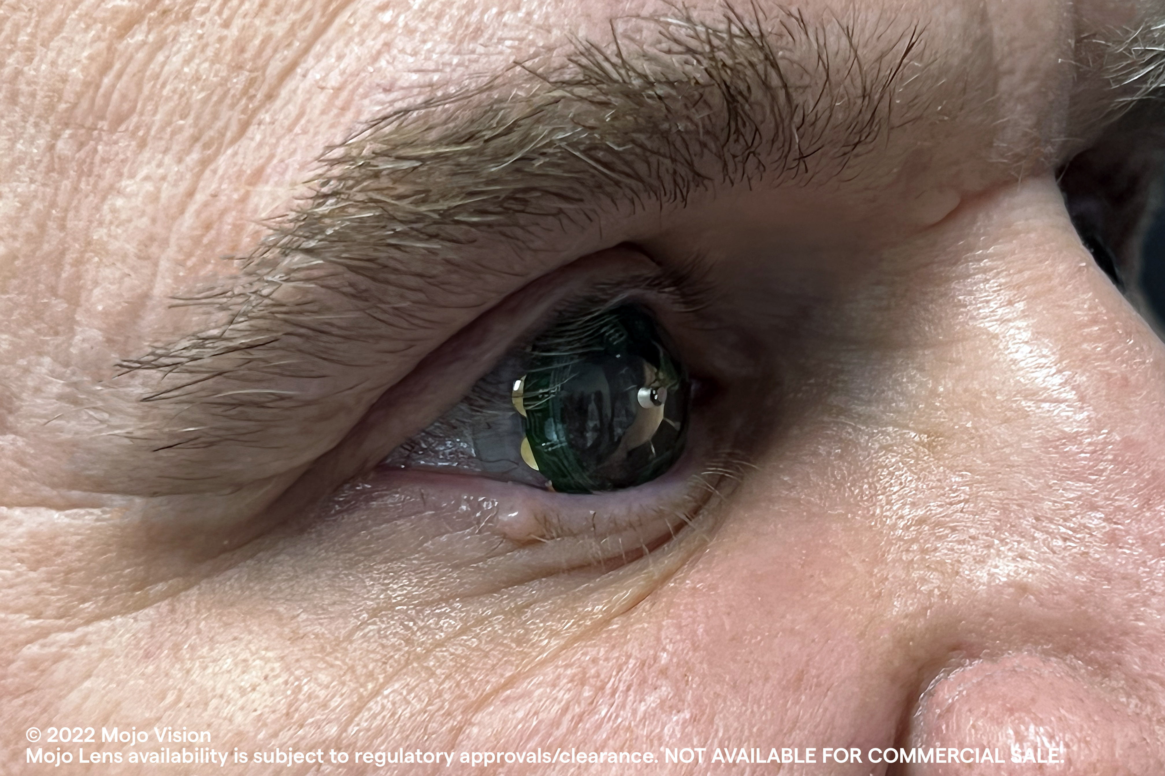 A man wears a Mojo Lens in his eye, you can see his eye in the close-up.