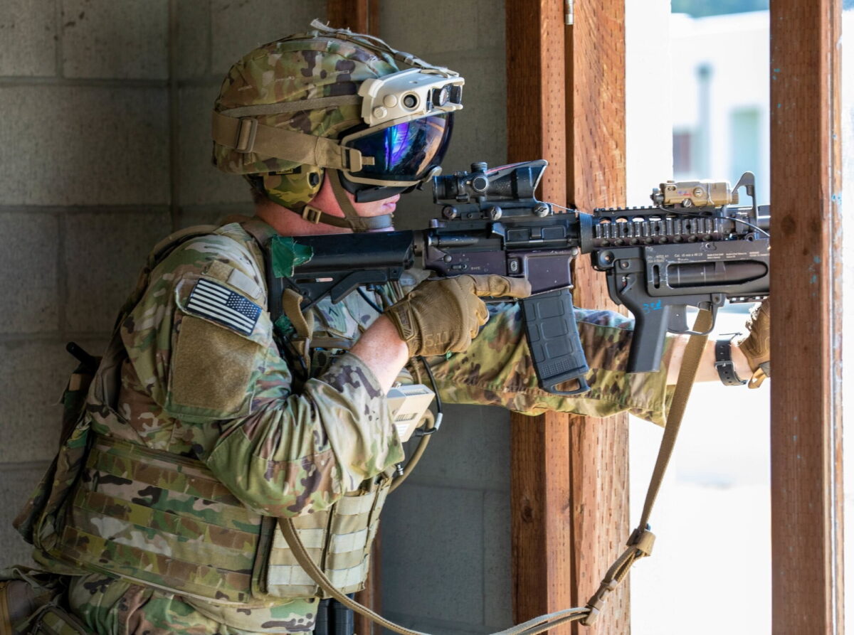 A soldier puts on an assault rifle in urban combat with the AR headset IVAS.