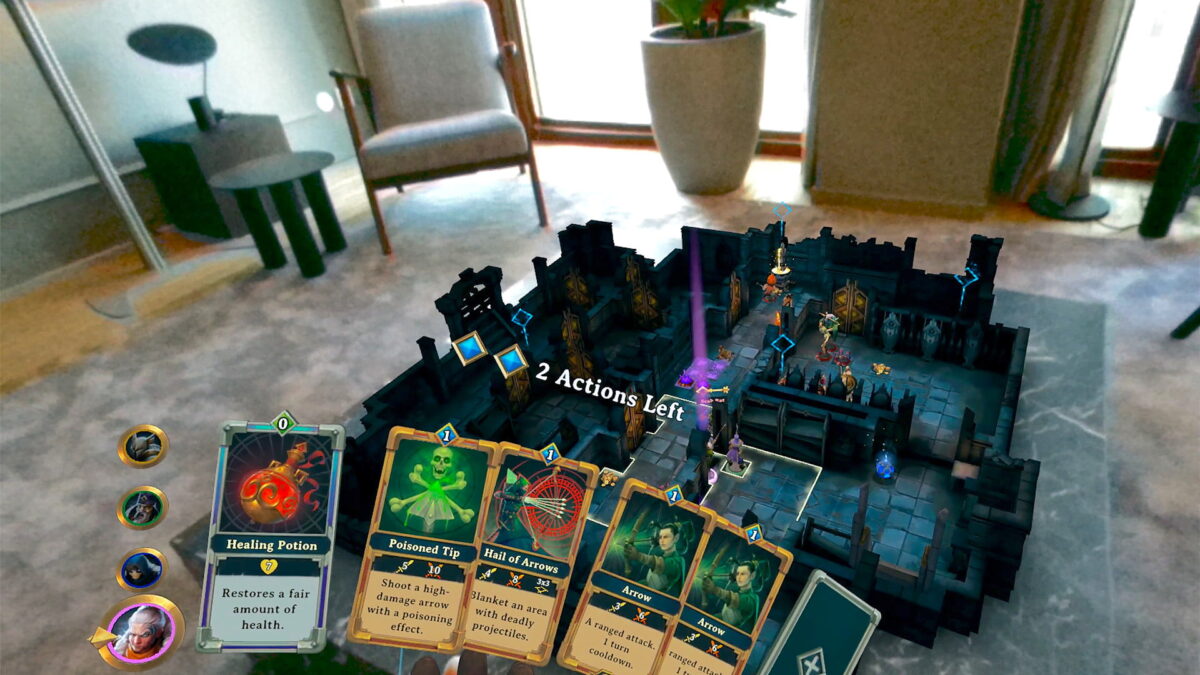 A digital game board on a physical table, the player looks at the digital cards he has.