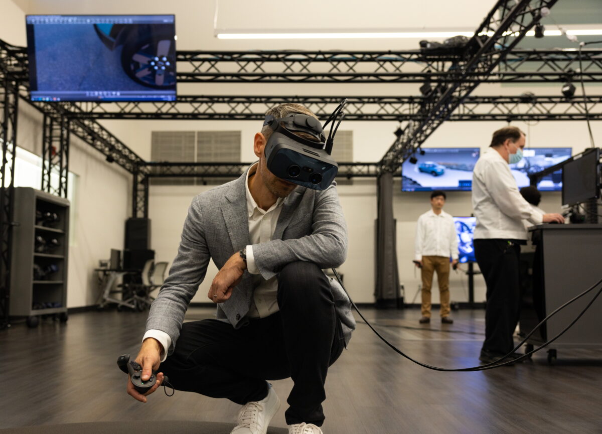 Honda's VR design leader Mathieu Geslin checks out a vehicle design while crouched down, wearing Varjo VR headset.