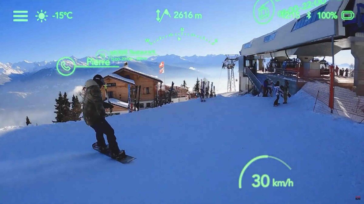 The view through ski goggles with AR display shows a snowboarder, the slope and virtual elements such as a speed indicator.