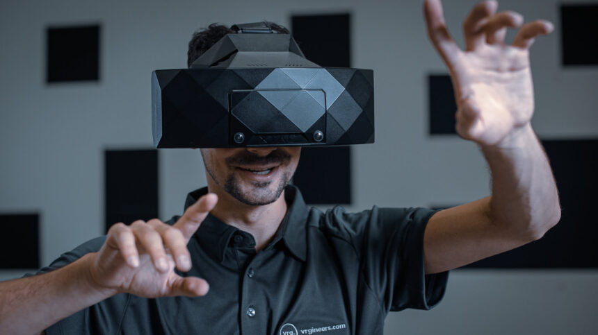 A VR user wears the Xtal 3 and uses hand tracking in front of it.