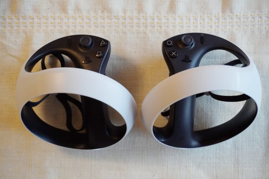 The two controllers of the PSVR 2 lie next to each other on a white tablecloth.