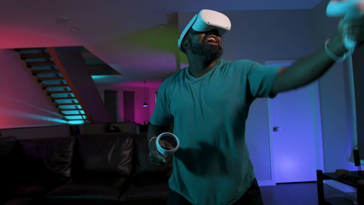 A man wearing VR headset wields the VR controllers.