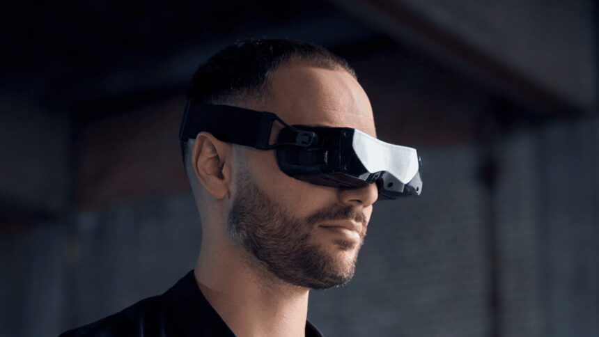 A man wears the tiny PC VR headset Bigscreen Beyond.