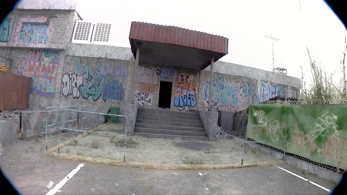 Opening scene from the viral Unrecord video showing the entrance to a run-down, abandoned building complex.