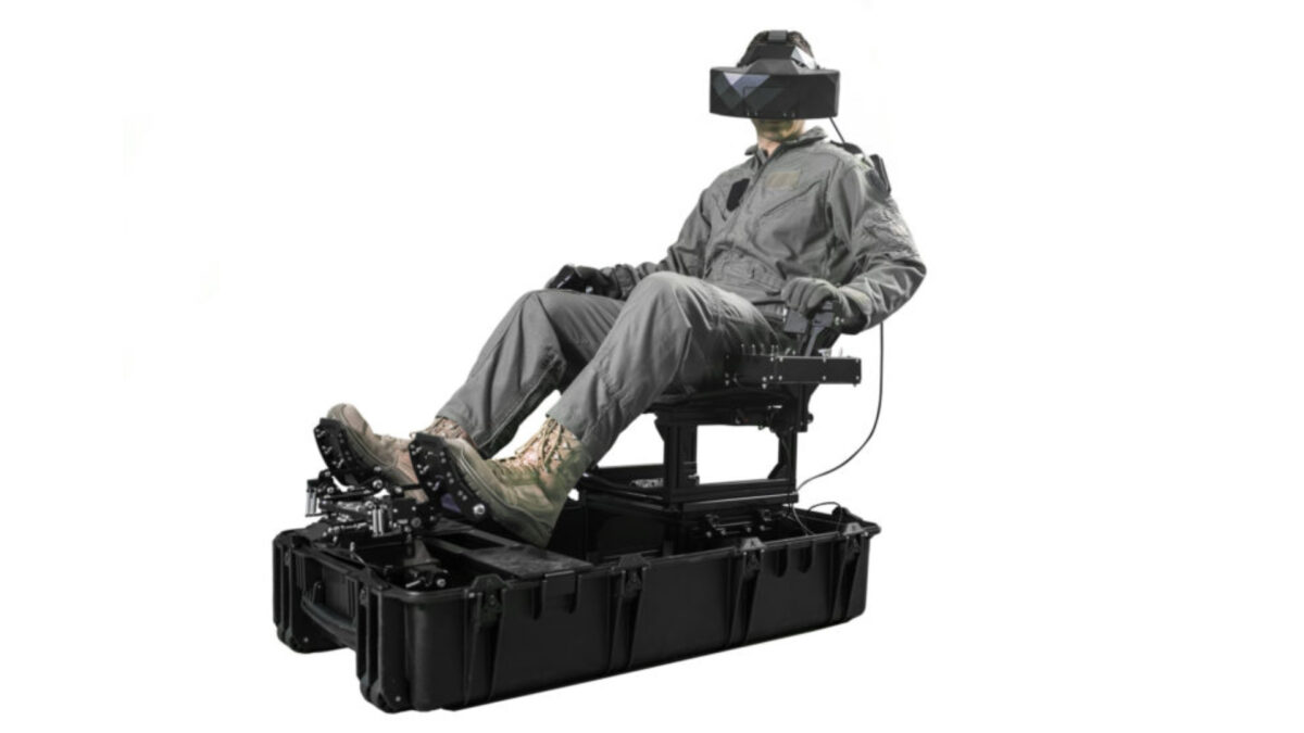 A pilot sits in a portable pilot trainer wearing a vr headset.