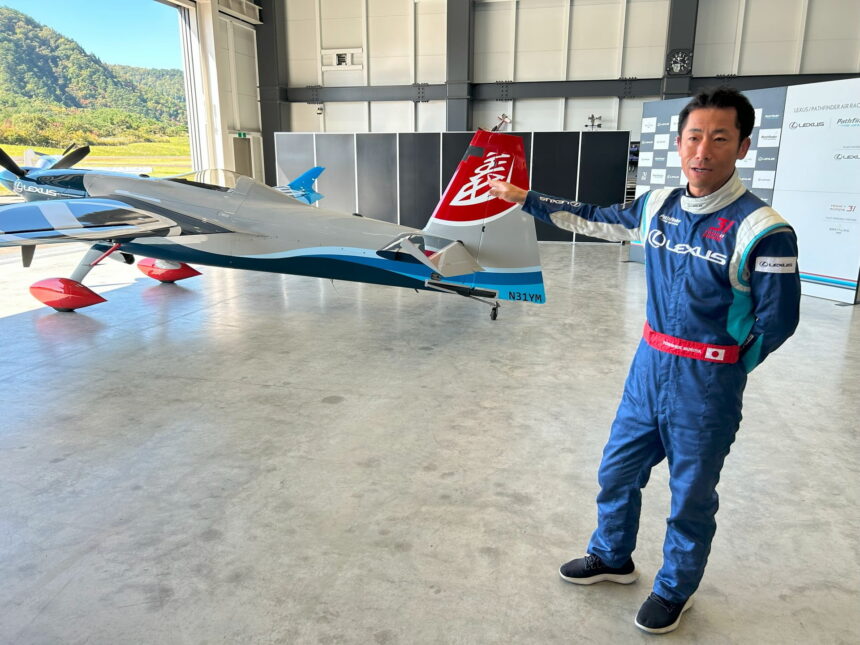 Pilot Yoshi Muroya points to his aircraft in the hangar at Fukushima Air Park