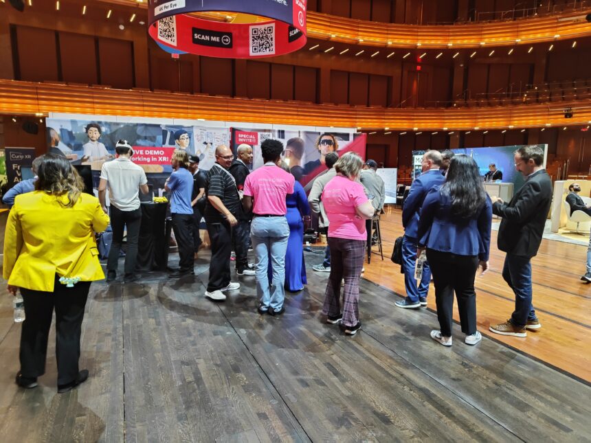 People standing in an expo space, one wearing a VR headset