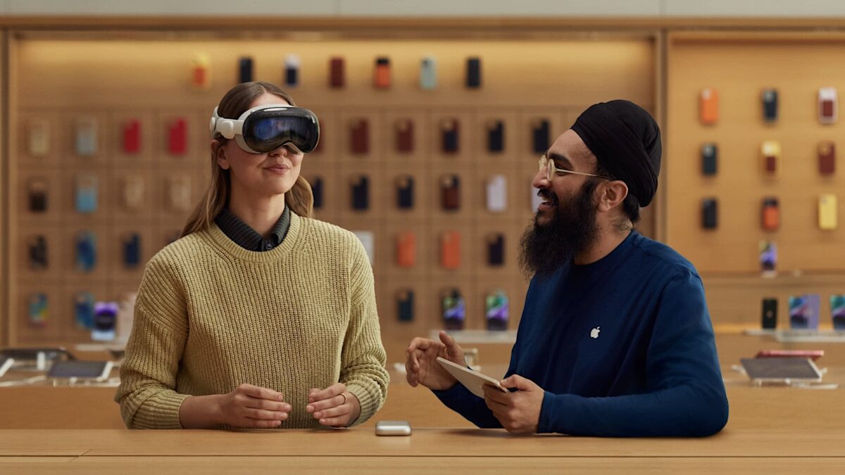 Woman trying out a Vision Pro in the App Store, a store employee next to her.