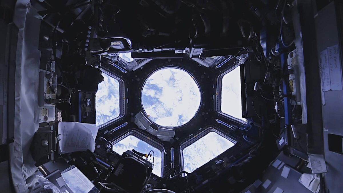 View into the dome of the ISS, with Planet Earth behind it.