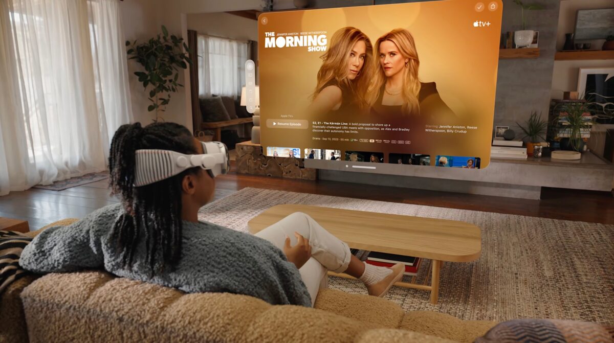 A woman sits on the couch at home and watches a series with Vision Pro.