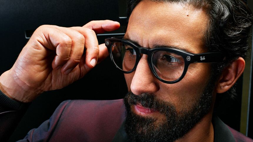 Man with beard wears Ray-Ban | Meta Smart Glasses and operates them with his right hand.