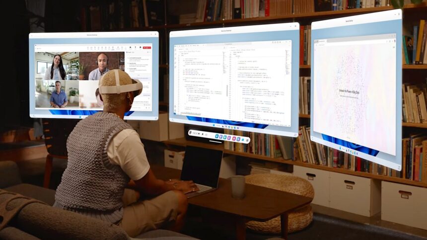 A person sits on a couch with Quest 3S and sees three virtual W11 work monitors in front of them.